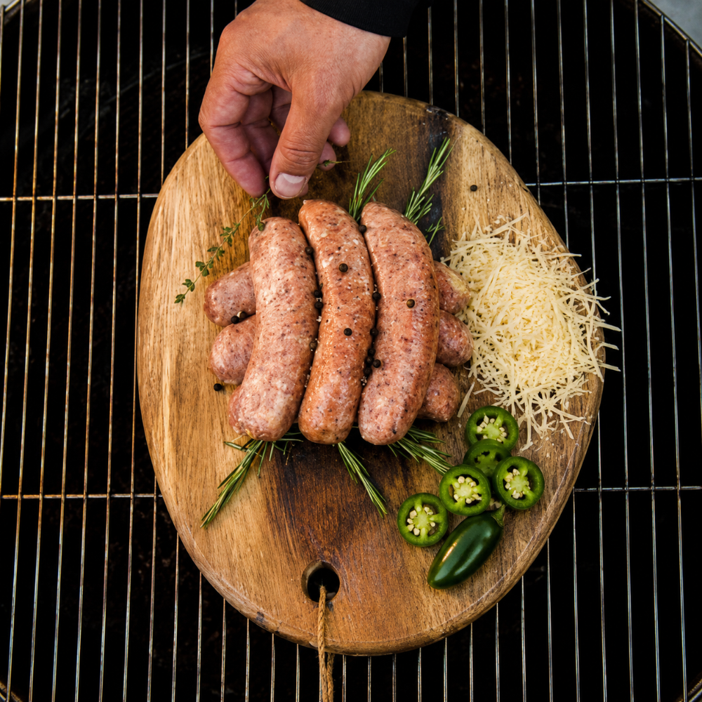 Worsten op houten plank met kruiden, cheddar en jalapeno